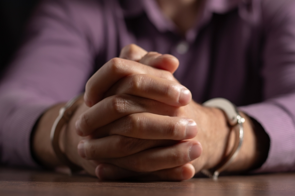 Businessman arrested for corruption. Man in a suit with handcuffs on his hands