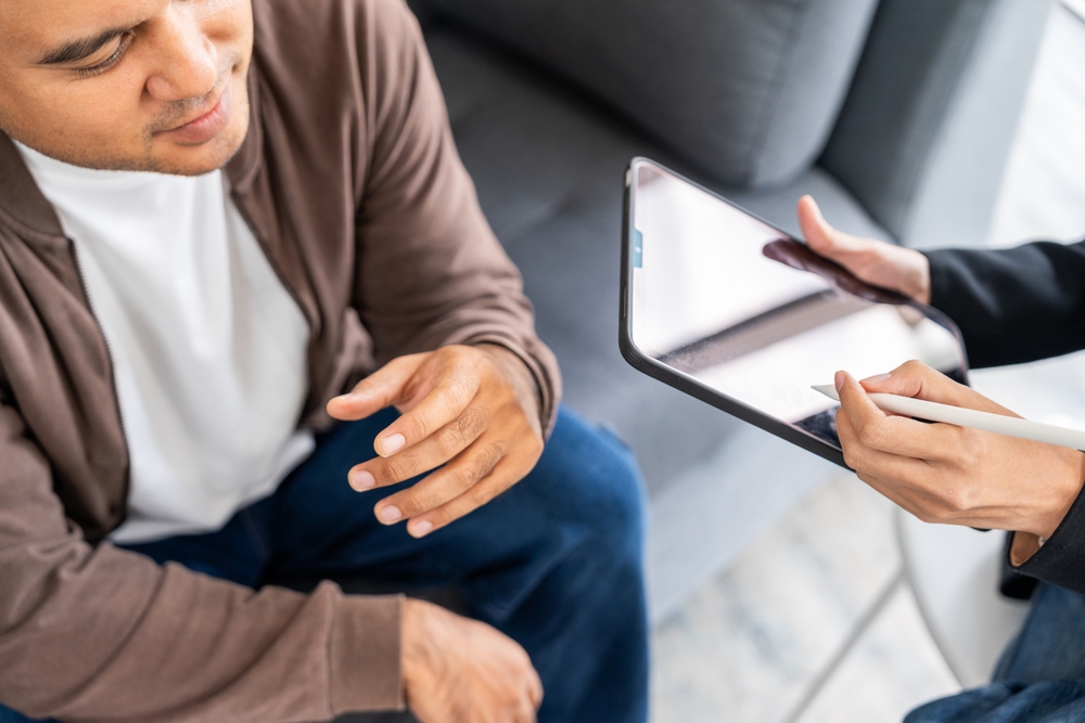 A male mental health patient consults a psychiatrist undergoing therapy and psychological assessments